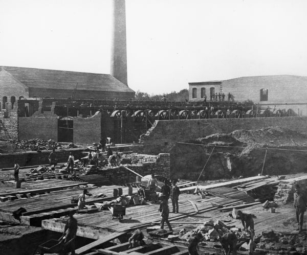 Elevated view of workers during construction of a paper mill.