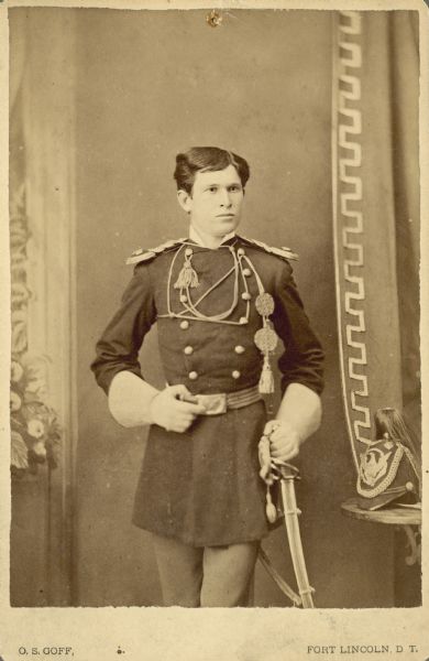 Three-quarter length studio portrait of L.R. Hare in full dress uniform in front of a painted backdrop. He was a First Lieutenant in the U.S. 7th Calvary. He is also a member of the Sturgis family.