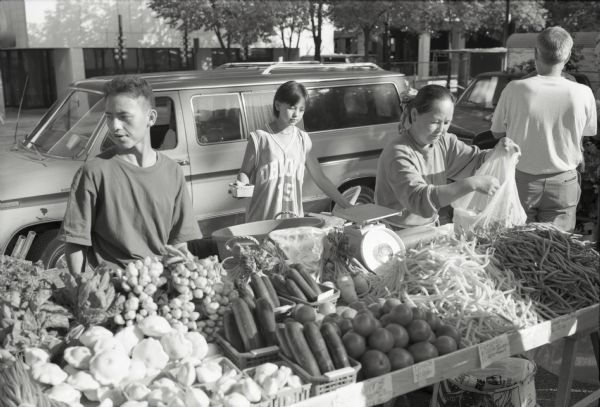 Hmong farm family selling vegetables on Mifflin Street on the Capitol Square at Madison's Farmer's Market.