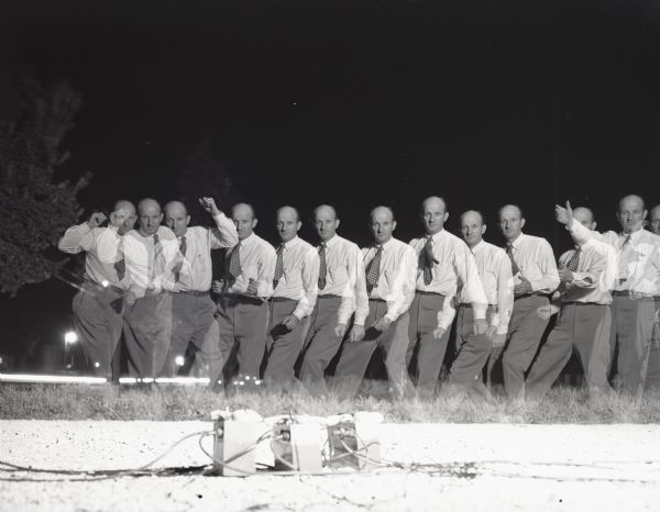 Strobe photograph of Frank Scherschel walking on grass. There are thirteen different exposures showing Scherschel's movements across the frame.