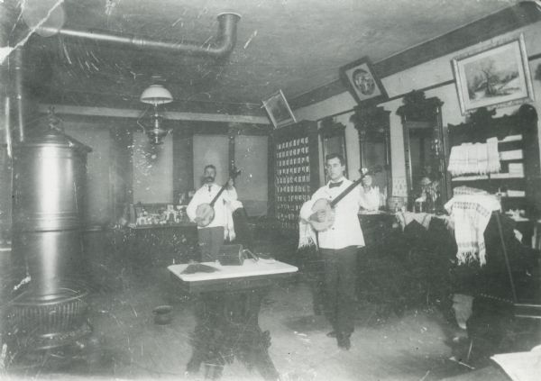 Rube Guyett and George Mandle with banjos in the Guyett Barber Shop.