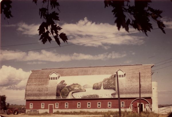 Gothic roofed barn with river scene painted on its roof by Frank Engebretson.