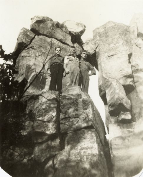 Devil's Lake State Park Civilian Conservation Corps workers posed at rock formation, possibly Devil's Doorway.