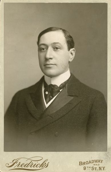 Quarter-length studio portrait of Henry Harris, wearing a double-breasted suit, tie, and tie pin.