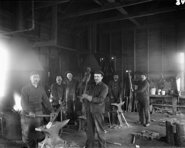 The blacksmiths of the mining company pose in their shop with the tools of their trade. The man on the right holding a sledgehammer is probably Dave Endrizzi.