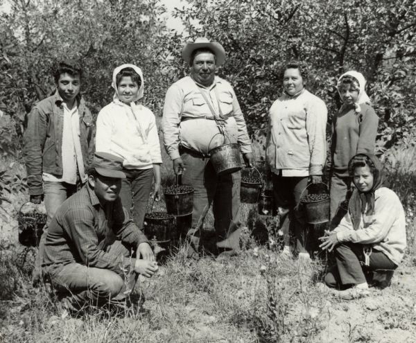 Filiberto Almendarez and his children, who are migrant workers, pose in front of cherry trees. The family, including Filiberto and children, Filiberto Jr., 22; Maria, 19; Elida, 18; Abel, 17; Anastasia, 15, and Florencia, 13, traveled from their home in Carrizo Springs, Texas to pick cherries for James Erickson in Door county. The family was also accompanied by Florencia, not pictured, Filiberto's wife and mother of the children. Filiberto immigrated to the United States from Mexico, and he and his family spent four months each year following crops as migrant workers.