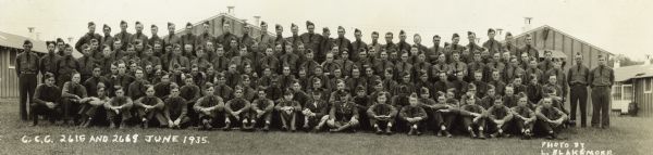 Panoramic group portrait of Civilian Conservation Corps workers from Camps 2615 and 2669 at Devil's Lake State Park. All men are in uniform. Officers are front and center.