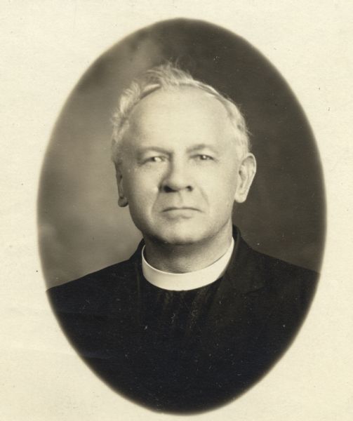 Quarter-length studio portrait of Reverend Waclaw Kruszka in priest's collar.