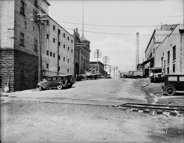 Looking north uphill on S. Blount Street toward Williamson Street, across the railroad tracks. The Fauerbach Brewery is on the left, and there is a smokestack in the background.