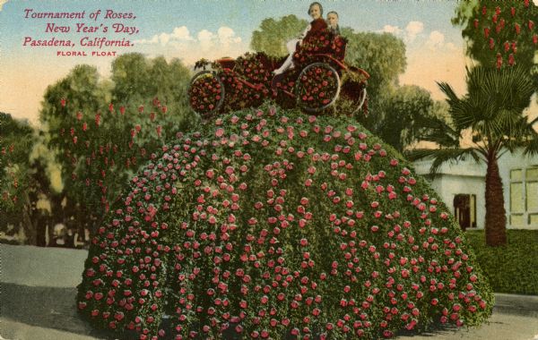 Postcard view of a couple seated on a floral float consisting of a car covered with roses atop a dome of foliage also covered with roses.