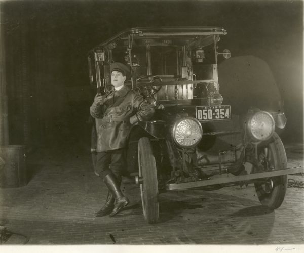 Night-time scene still from the Triangle silent film "Taxi," featuring Taylor Holmes (playing Robert Hervey Randolph) leaning on his taxi.