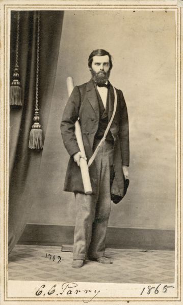 Full-length carte-de-visite portrait of Charles C. Parry (1823-1890), American Botanist. Parry is most famous for his botanical research in the southern Rocky Mountains of Colorado. A self-described "exceptionally unselfish and kind," man, Parry never published a book and catered more to the public at large than the scientific community, focusing on newly-discovered plants that he found to have ornamental value. Shown here standing in a full-length portrait, carrying a tube-shaped container. Handwritten inscription at the bottom reads, "C.C. Parry, 1865."