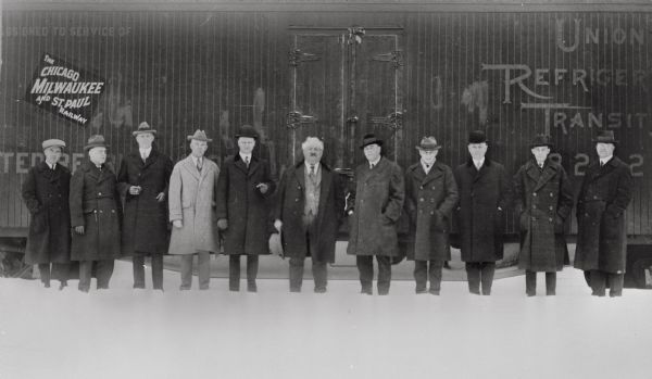 Union Refrigerator Transit Company officials pose in front of a railroad car in the snow. Governor Emmanuel Philipp is in the center of the line.