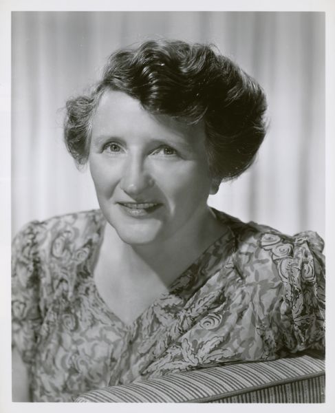 Publicity still of actress Marjorie Main in a print blouse. Caption reads: From Shakespeare... to modern comedy is the amazing career of Marjorie Main, popular Metro-Goldwyn-Meyer actress currently pitching woo with Wallace Beery in "Big Jack." Few filmgoers realize that the gravel-voiced comedienne actually began on the stage in Shakespearean stock prior to going to New York and Hollywood. Cast of her new film, a rip-roaring tale of bandits and romance in 1808 Kentucky, is headed by Beery, Richard Conte, Miss Main, Vanessa Brown, Edward Arnold, and Clinton Sundberg. Richard Thorpe directed, Gottfried Reinhardt producing.
