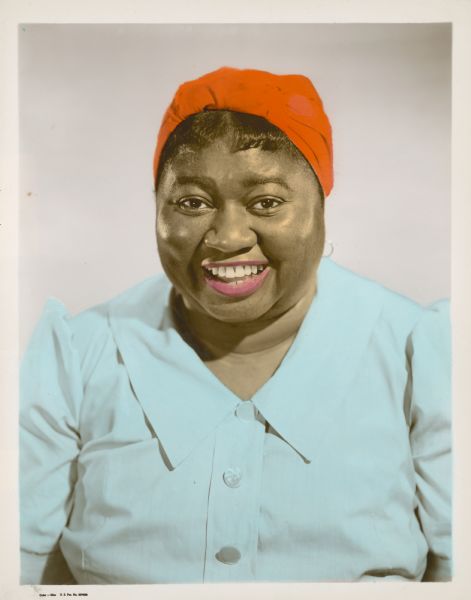 Publicity still of actress Hattie McDaniel, in head scarf and blouse.