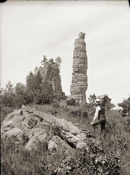Adams and Juneau Counties. Pillar Rock, Fort Danger. There is a man with an 8 x 10 camera in the foreground.