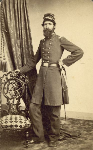 Studio portrait of Gen. T.S. Allen in uniform. He is standing with one hand on an ornate chair.