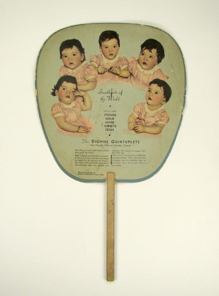 The reverse side of a promotional cardboard and wood fan featuring an image of the Dionne quintuplets. This back side of the fan is printed with an advertisement for Lakeside Dye Works.