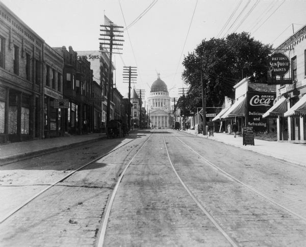 A view looking up King Street from Butler Street toward the Wisconsin State Capitol. It appears there is work being done on the dome.