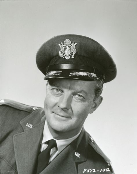 William Lundigan poses as his character Colonel Ed McCauley from the television show <i>Men Into Space</i>. He is wearing a military uniform and hat.