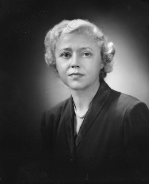 Quarter-length studio portrait of Elizabeth Nord wearing a pearl necklace.