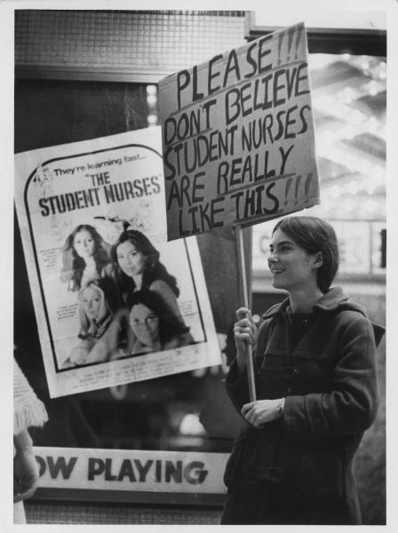 Susan Beckman, a student nurse at County General Hospital, carries a sign protesting the portrayal of nurses in a movie "The Student Nurses".