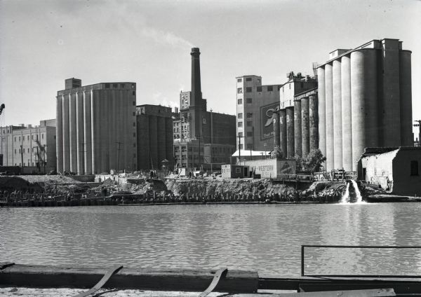 View across the Kinnickinnic River of the Pabst brewery grain elevator. A Schlitz building, possibly one of their grain elevators, stands behind the Pabst elevator.