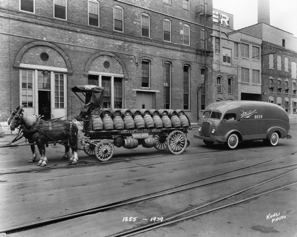 The Miller Brewing wagon, filled with barrels of beer, and a Miller delivery truck. The caption on the photograph reads "1855-1939".