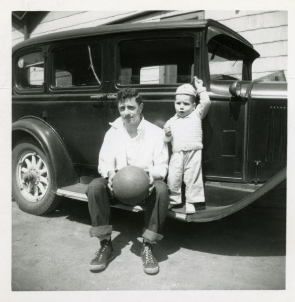 Father James Groppi, as a young man, and his nephew Jerry Bontempo, posing on the running board of a 1920's era vehicle. Groppi holds a basketball.