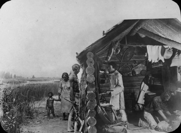 A diorama depicting several people, including a small child, gather at a fur trading post in Juneau, Alaska.