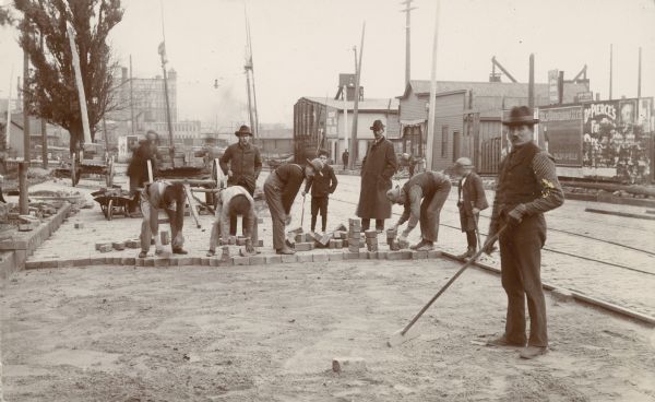 A crew of construction workers paving North Main Street with brick.
