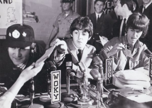 The Beatles at a press conference in advance of their concert that evening. Pictured: John Lennon, Paul McCartney, and George Harrison. Not pictured: Ringo Starr.