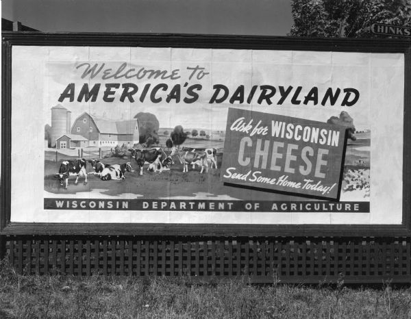 Wisconsin Department of Agriculture billboard promoting Wisconsin cheese with a picture of several cows on a farm.