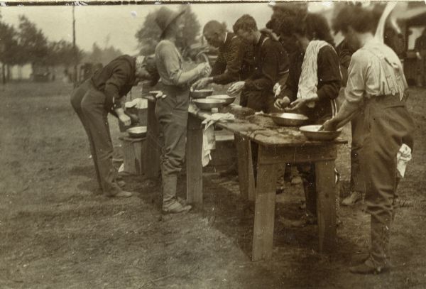 Wisconsin National Guard members washing their hands in metal pans before a meal.