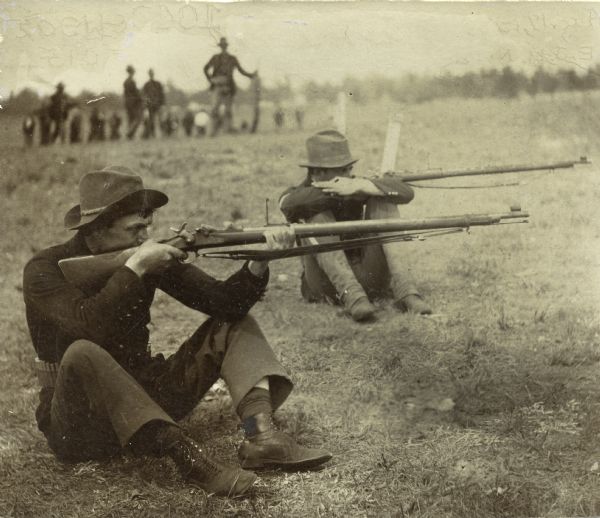 Wisconsin National Guard soldiers firing from a seated position at the Camp Douglas firing range.