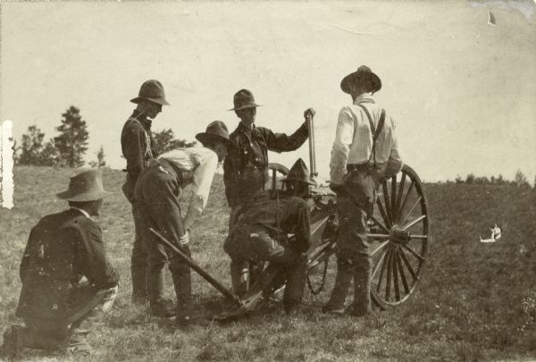Wisconsin National Guardsmen gathered around a cannon, possibly positioning it to aim at a target.