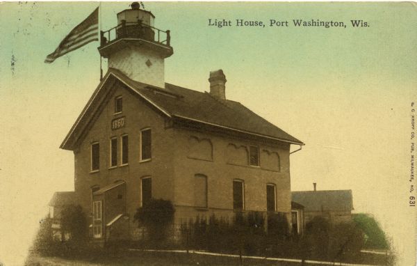 Tinted postcard view of the lighthouse at Port Washington. A U.S. flag flies above the roof at the upper left. Caption reads: "Light House, Port Washington, Wis."