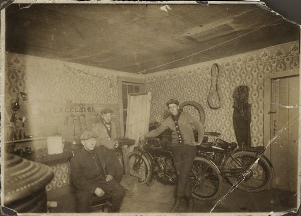 View of interior of a Madison bike shop. Small & Stevens Bike Shop on State Street. The person sitting in the foreground on the left is believed to be Hubbard Stevens Jr.