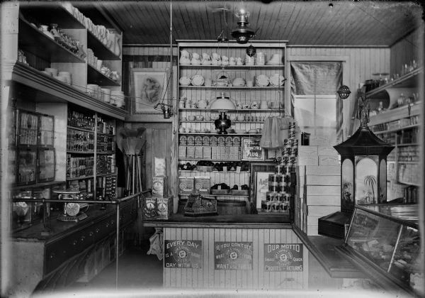 Interior of a general store displaying various merchandise in glass cases, shelves and counters.