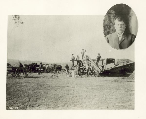 A scene in a field of men posing on and near a thresher. A man sits on a wagon with four or five pairs of horses standing around him. There is an oval-shaped portrait of an unidentified man inset in the upper right corner of the image.