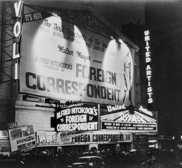 The Rivoli Theater in Times Square the night the film "Foreign Correspondent" premiered there. Above the marquee is a large banner covering the front of the building lit up by two spotlights.