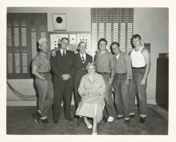Group publicity photo for the film "Riot in Cell Block 11." There are six men standing behind an unknown seated woman. Left to right: Dabs Greer, Emile Meyer, unknown man, Neville Brand, Robert Osterloh, and Leo Gordon.