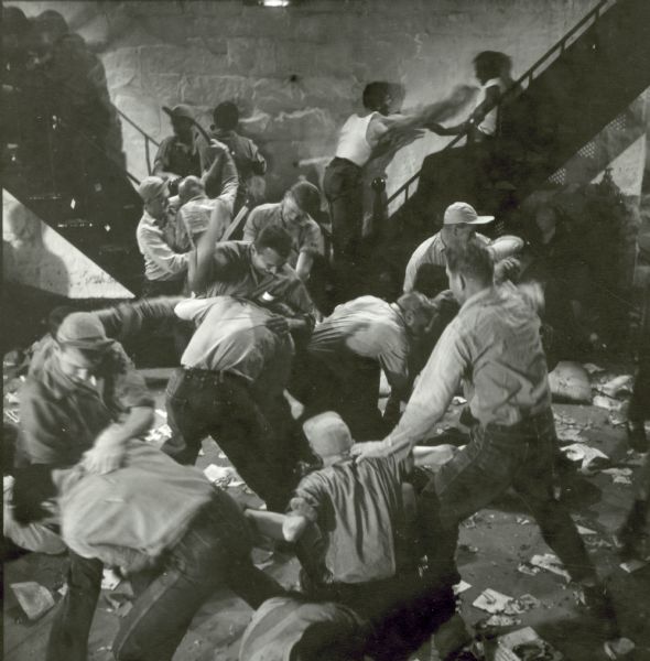 Prisoners are seen fighting on the set of the film "Riot in Cell Block 11." They are fighting on the floor and on two metal staircases.