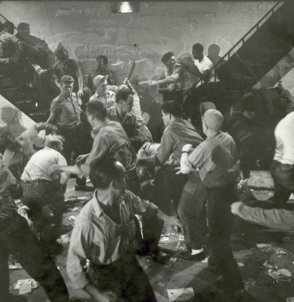 Prisoners are seen fighting on the set of the film "Riot in Cell Block 11." They are fighting on the floor and on two metal staircases.
