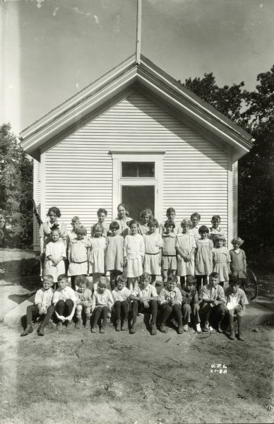 Outdoor group portrait of the Mendota Beach School group in front of a school building.