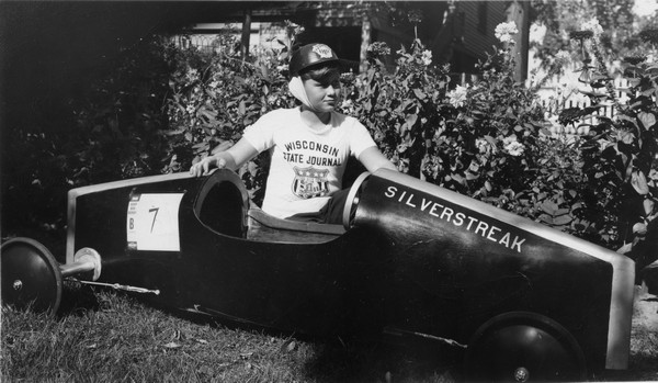 Philip Lenhart with his soap box derby car, <i>Silverstreak</i>. Lenhart wears a helmet and a Wisconsin State Journal t-shirt.