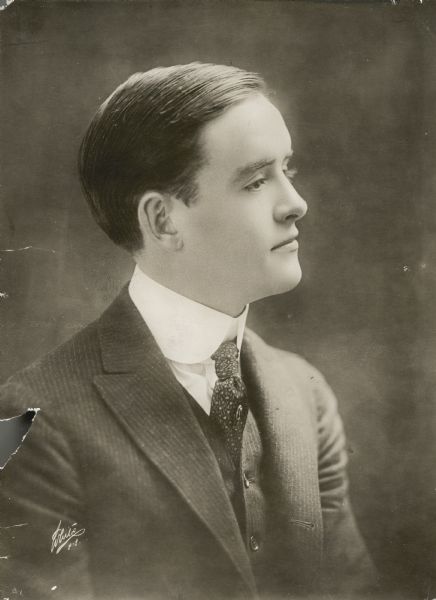 Waist-up profile portrait of actor Robert Harron. He is wearing a suit coat, vest, tie and dress shirt.