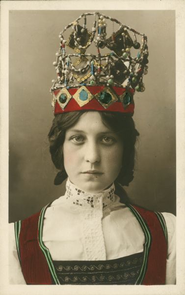 Head and shoulders portrait of a woman in traditional Scandinavian dress, including an ornate headdress.