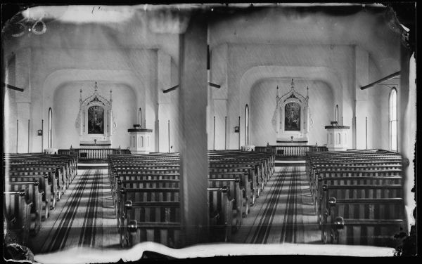Interior view of church from the rear towards the altar, probably Luther Valley Church, originally built in 1863. A steeple was added in the 1870s. The altar, with a painting above it, is credited to Norwegian-American Aslak Olsen Lie.