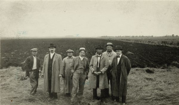 Group of well-dressed men standing in front of a plowed segment of Horicon Marsh.